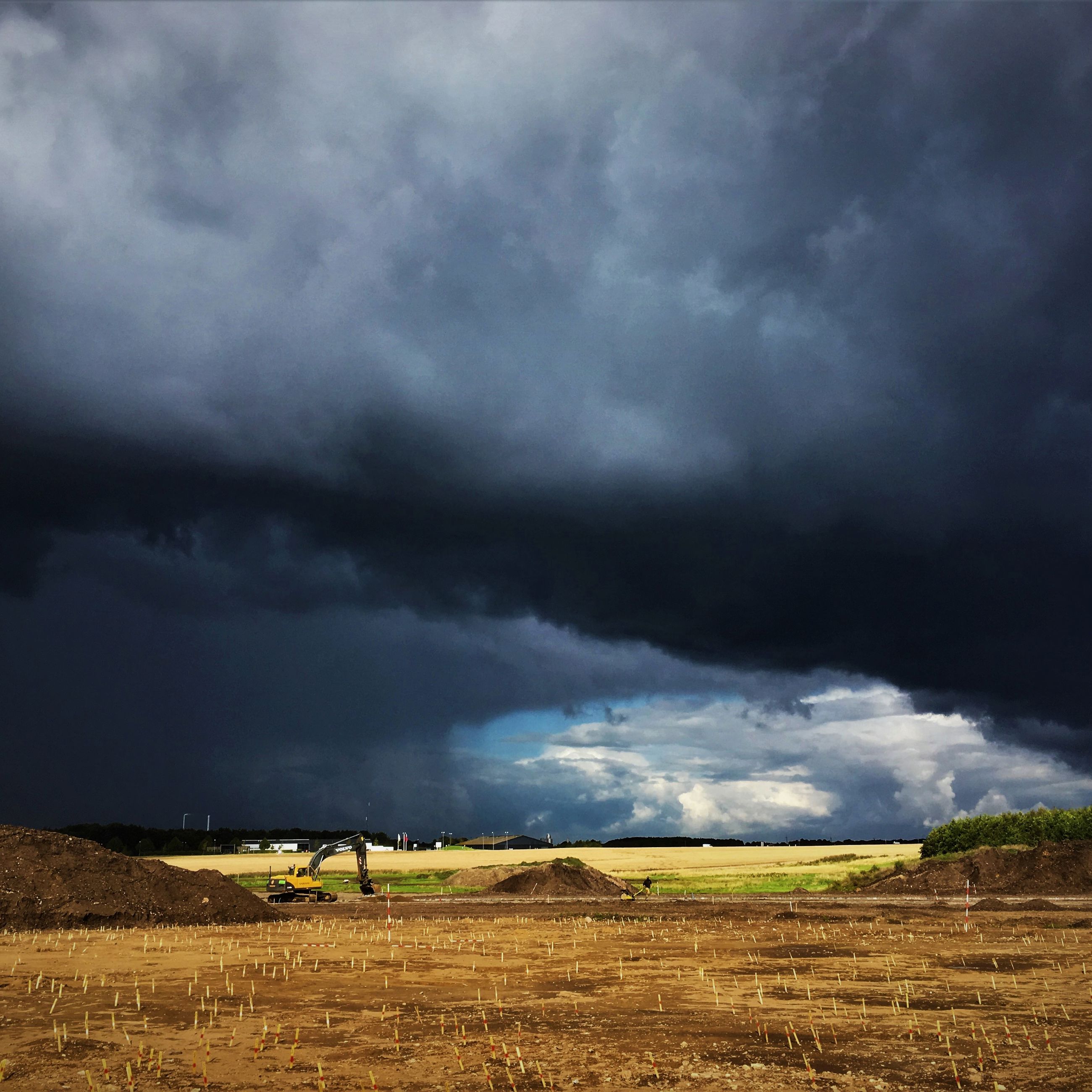 Dramatiske skyer over arkæologisk udgravning